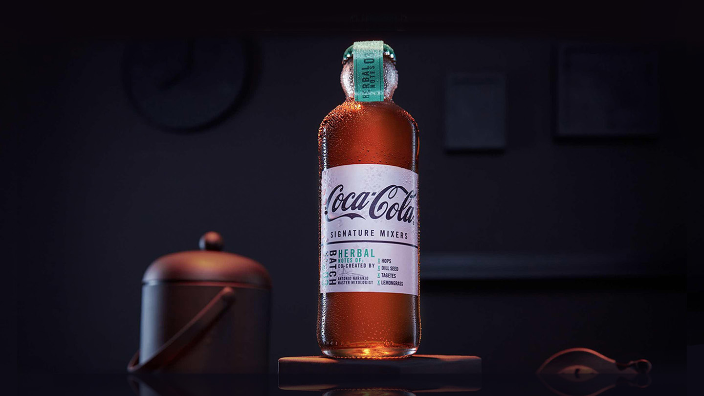 Coca-Cola Signature Mixers bottle in a dimly lit room.