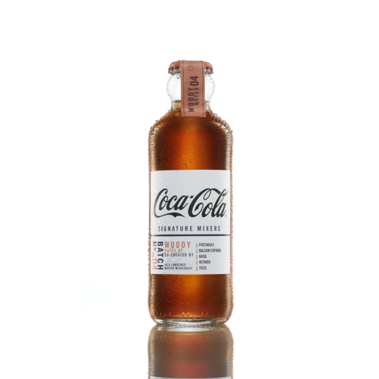 Coca-Cola Signature Mixers Woody Notes bottle on white background.